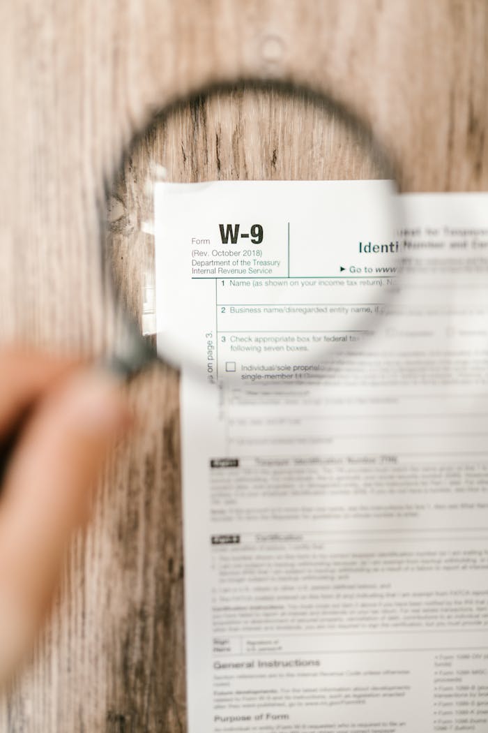 Focused view of a W-9 tax form magnified, illustrating attention to detail and finance.